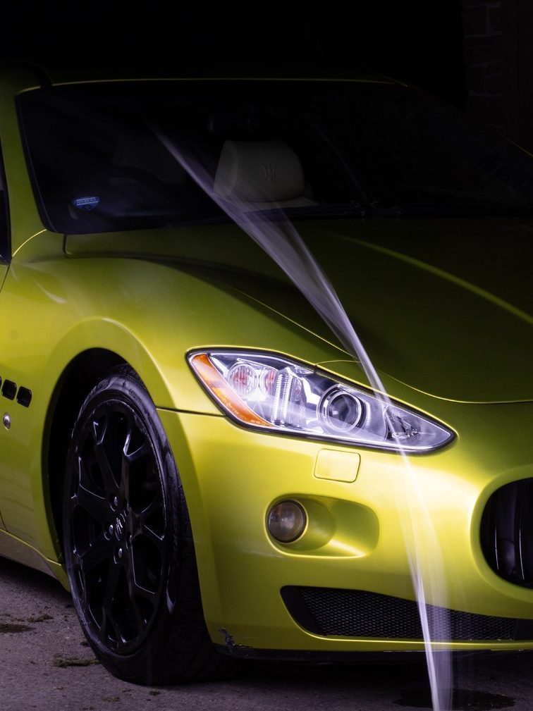Nicely lit lime green Maserati front view in the dark after a full detail